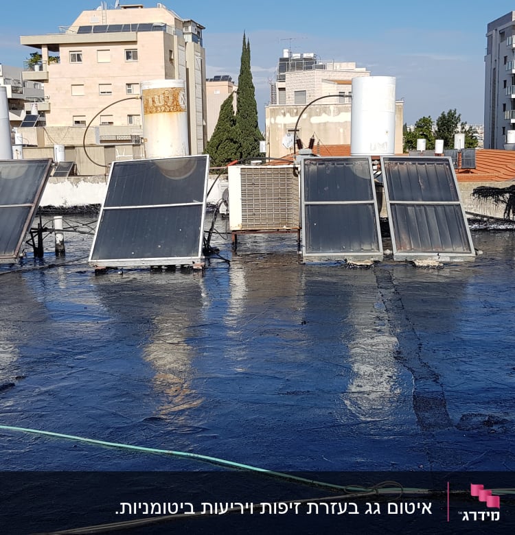 גג אטום בזפת עם דודי שמש וקולטים